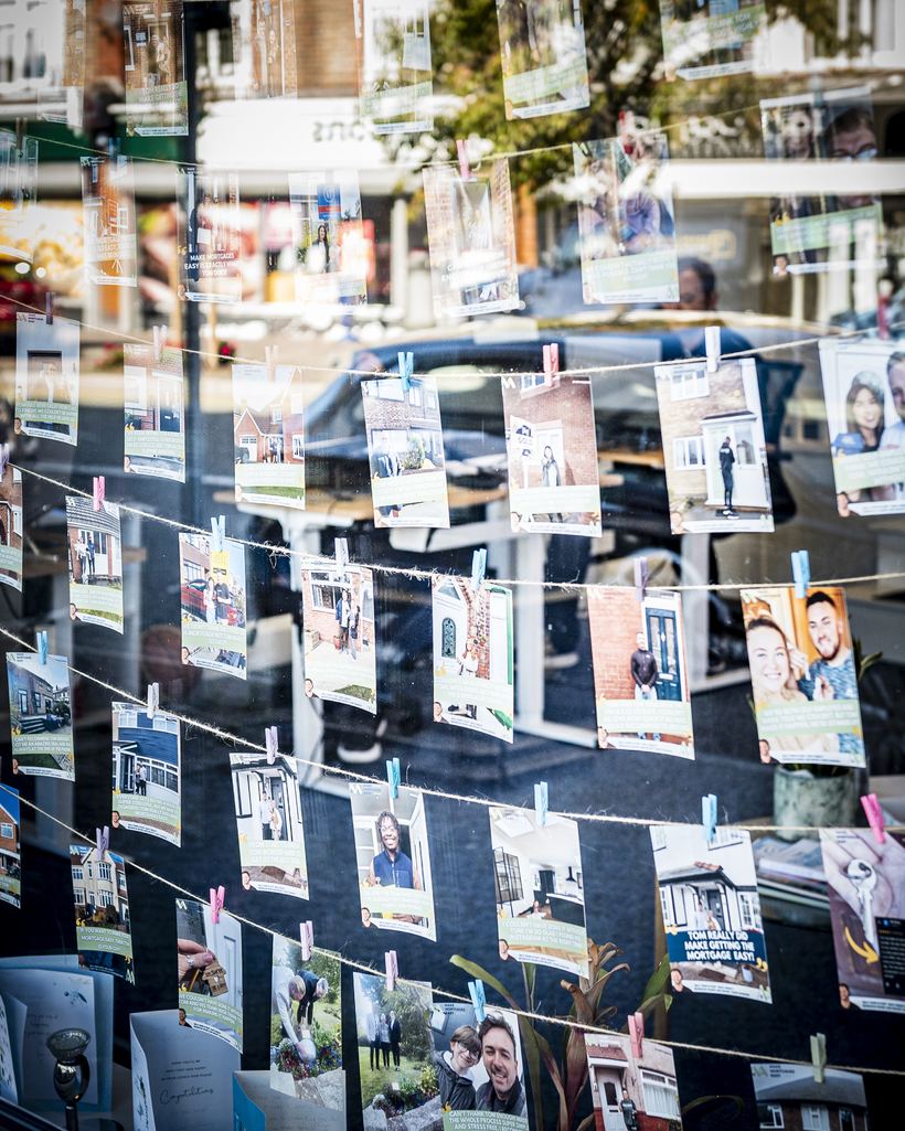 The office window, hung with photographs and thank-you notes from clients who have completed